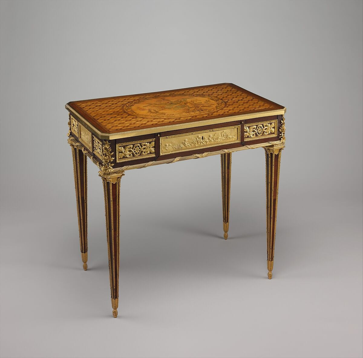 Marquetry mechanical table with gilt bronze mounts and fluted, tapered legs, by Jean-Henri Riesener