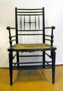 A Morris & Co. Sussex chair in ebonized wood with turned legs, spindles and a rush seat