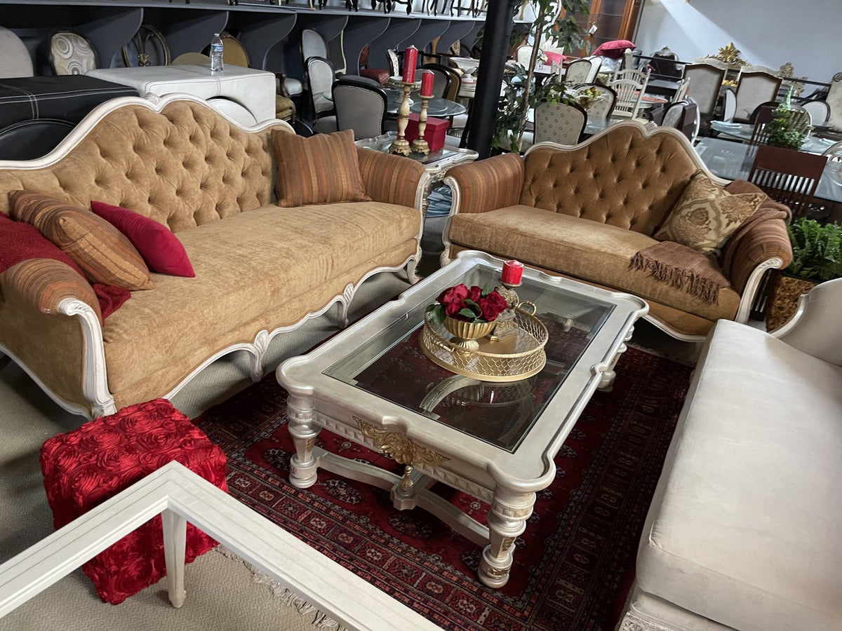 Tufted camel sofa and loveseat with white carved frames in the Sigla showroom