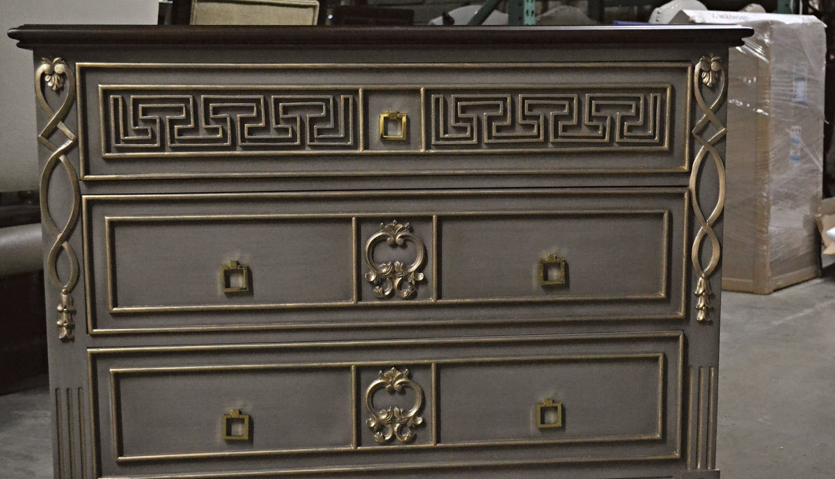 Front view of a painted chest of drawers with gilded Greek key and carved pilasters, built by Sigla