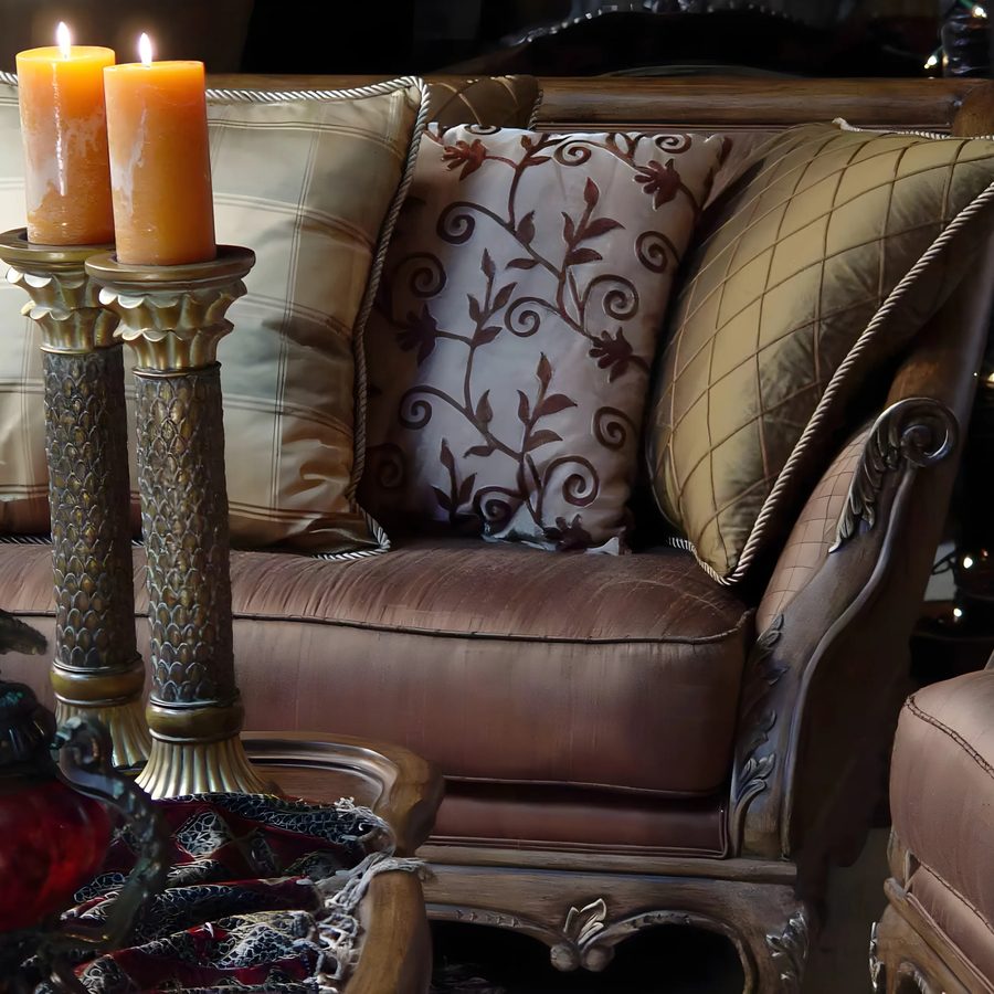 Leather sofa with patterned pillows beside carved candle holders